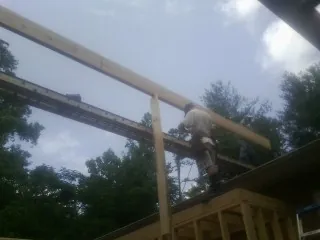 Carpenter setting a ridge beam over a new addition frame — Ice Dam Removal by Roofing Brothers in Lincoln City