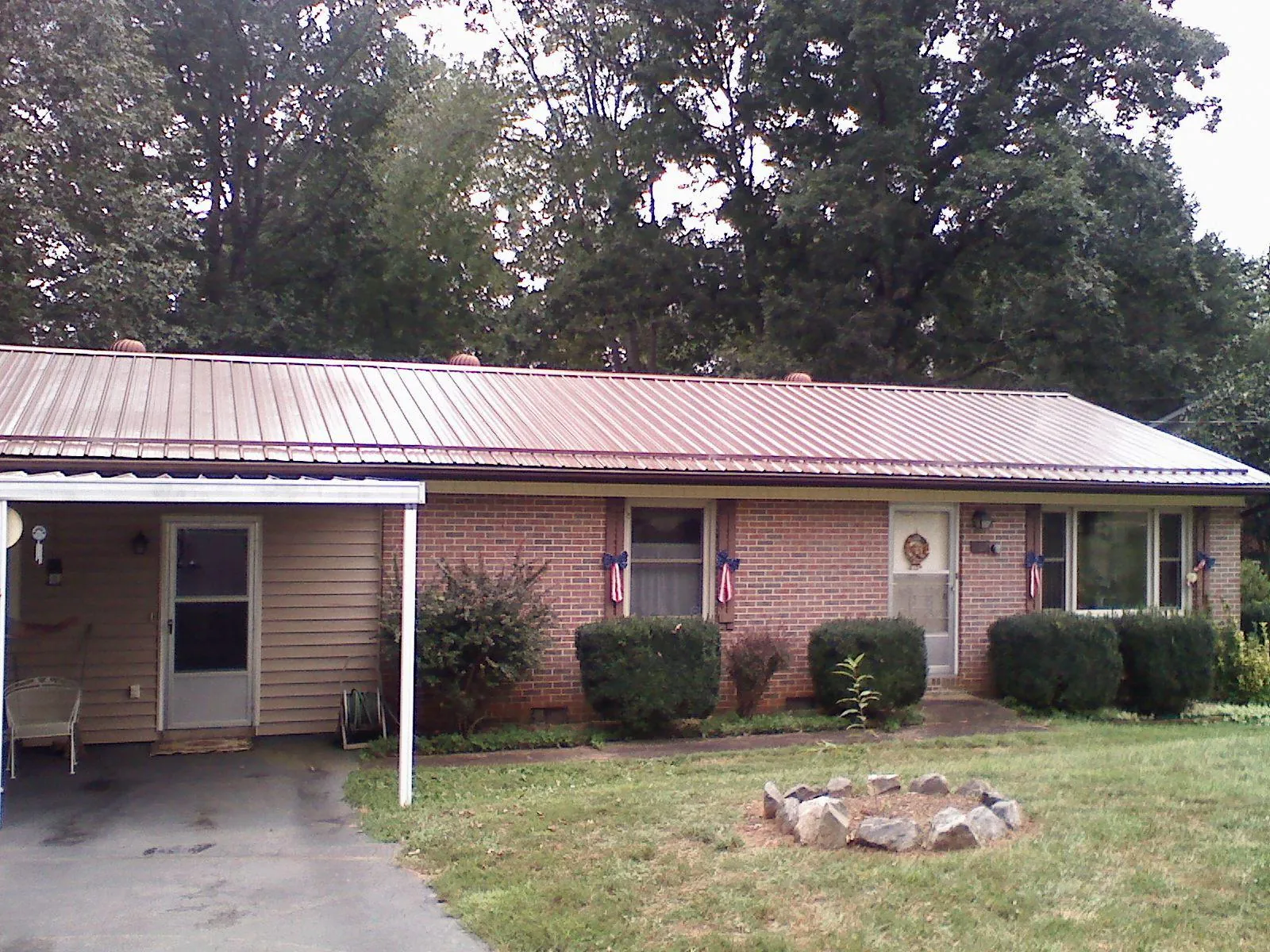 Bronze metal roof and carport on a brick ranch home — Roof Repair work by our crew in Lincoln City